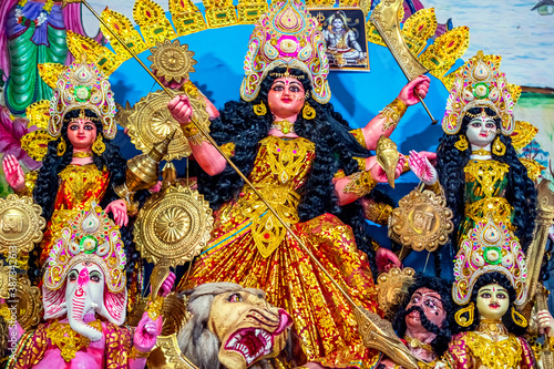 Decorated sculpture of goddess Durga idol on lion with ten arms at pandal and temple in colored light. Durga Puja is big cultural Hindu religious festival in west Bengal, India. Navaratri background.