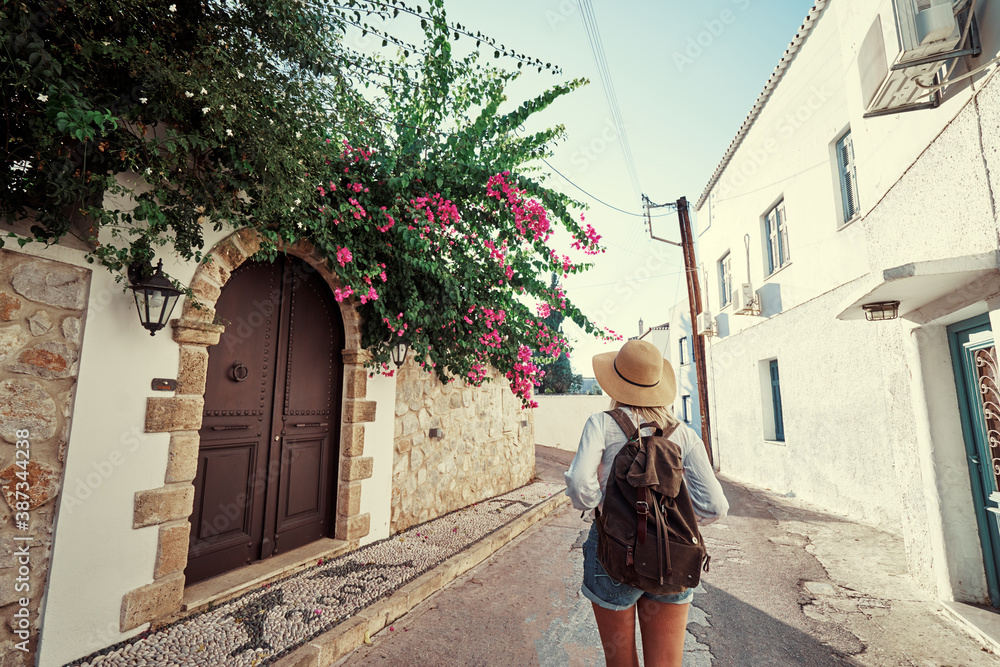 Enjoying vacation in Greece. Young traveling woman walking on Greek Old Town.