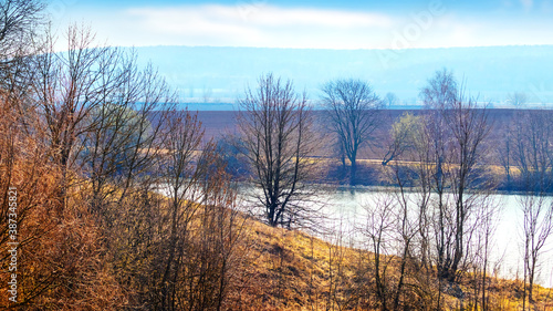 Spring landscape with trees on a hill near the river