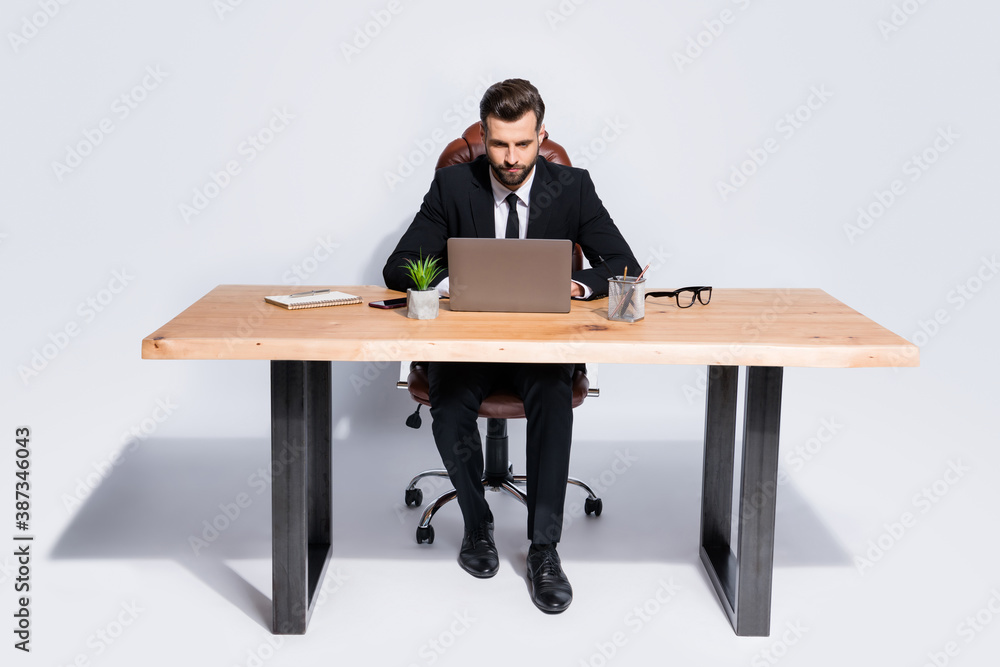 Photo of handsome business guy notebook table chatting colleagues partners seriously read corporate report wear black blazer shirt pants shoes suit sitting chair isolated grey background Photo of handsome business guy notebook table chatting colleagues partners seriously read corporate report wear black blazer shirt pants shoes suit sitting chair isolated grey background
