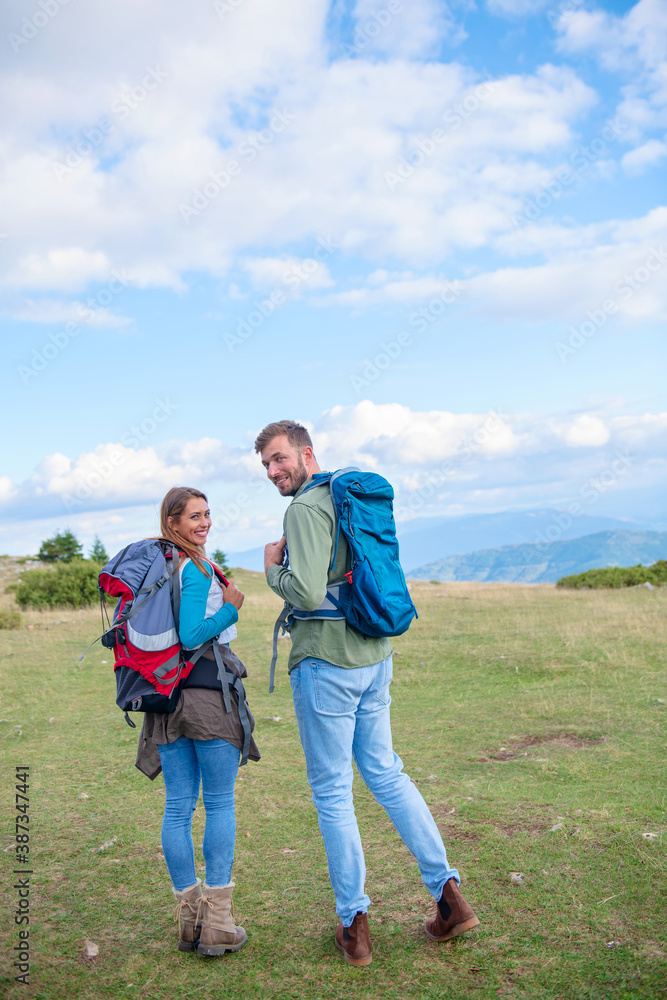 Happy couple hiking and enjoying a valley view Happy couple hiking and enjoying a valley view