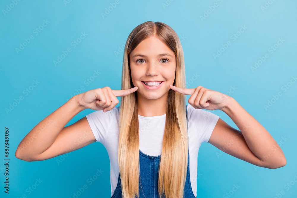 Close-up portrait of nice-looking cheerful blond girl showing teeth whitening effect isolated on pastel blue color background Close-up portrait of nice-looking cheerful blond girl showing teeth whitening effect isolated on pastel blue color background