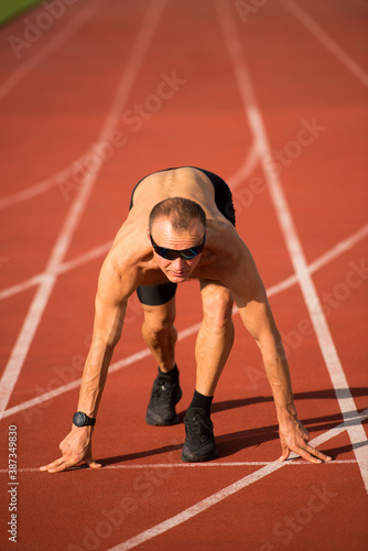 Male runner preparing for the start on the track