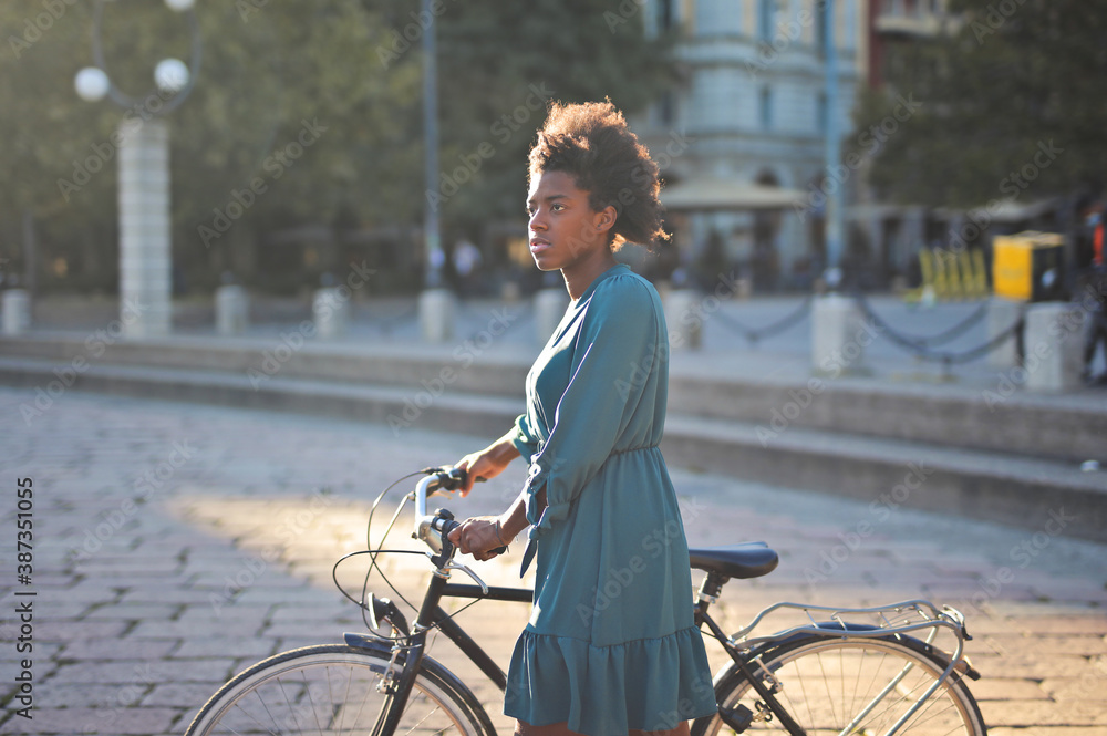 young woman with a bicycle in the city