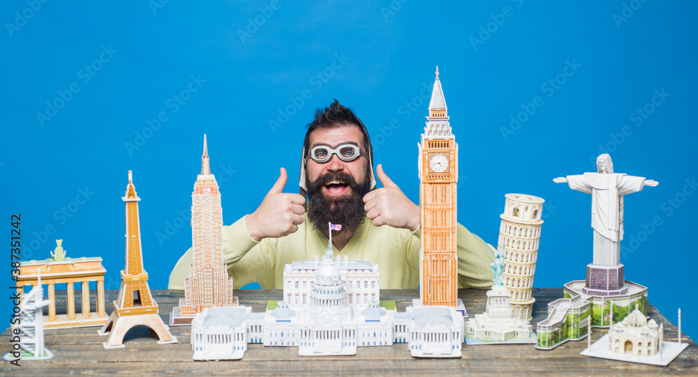 Traveling concept. Travel and vacation. Worlds monuments copy. 3d puzzles. Bearded man with 3d puzzles. Miniature buildings models. Man traveling. - obrazy, fototapety, plakaty 