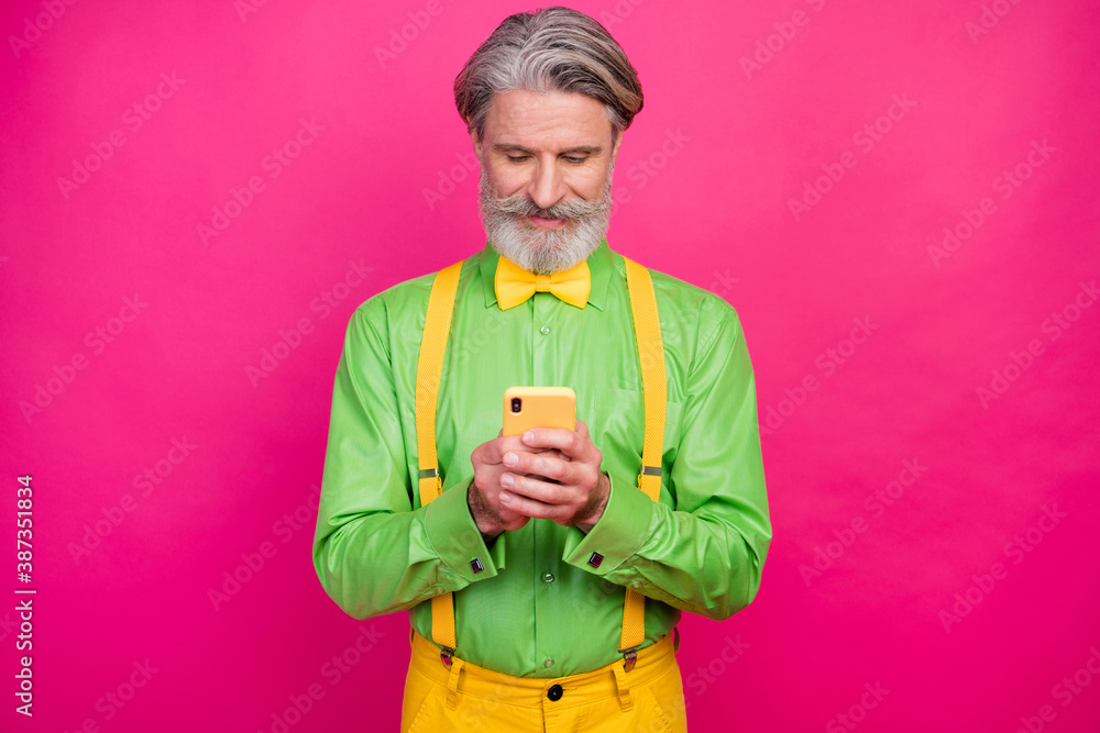Photo of nice aged grandpa ideal mustache hold telephone pretend millennial read blog post wear green shirt yellow suspenders bow tie pants isolated bright pink color background Photo of nice aged grandpa ideal mustache hold telephone pretend millennial read blog post wear green shirt yellow suspenders bow tie pants isolated bright pink color background