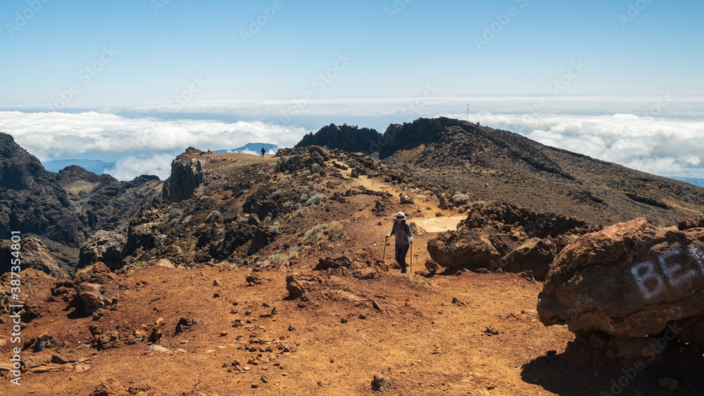 Obraz premium Woman walking on a path in the mountains towards Piton des neiges