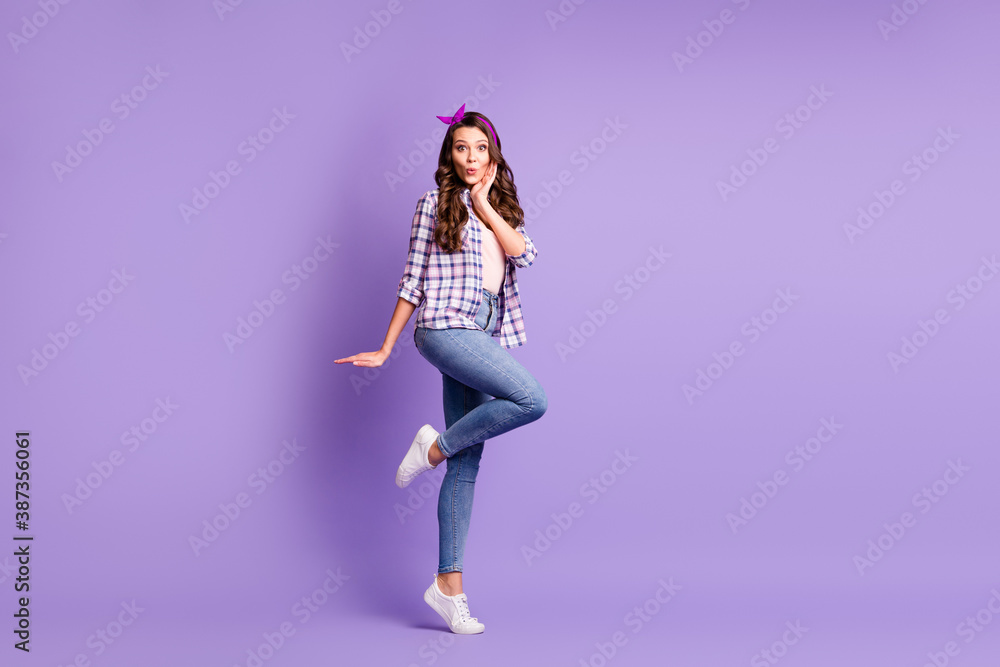 Full length profile photo of lady arm cheekbone stand tiptoe wear plaid shirt headband jeans footwear isolated violet color background