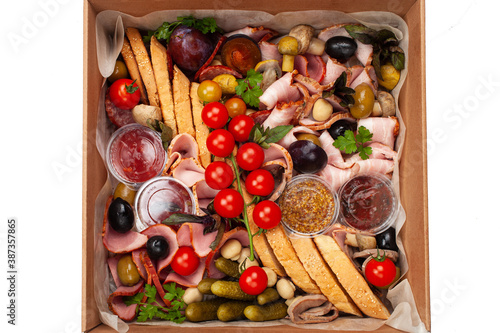 Delivery of food in a box, delicious and fresh food. Convenient boxing for eating at home, at work, in nature. Tomatoes, greens for decoration, bread and ham.