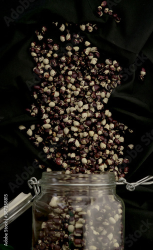 jar of beans and legumes on black background