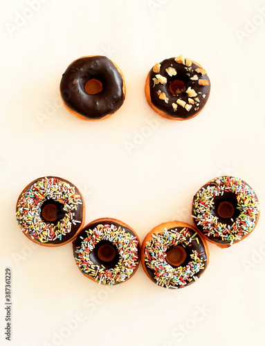 Delicious chocolate donuts isolated on a white background. Happy smiley donuts. 
