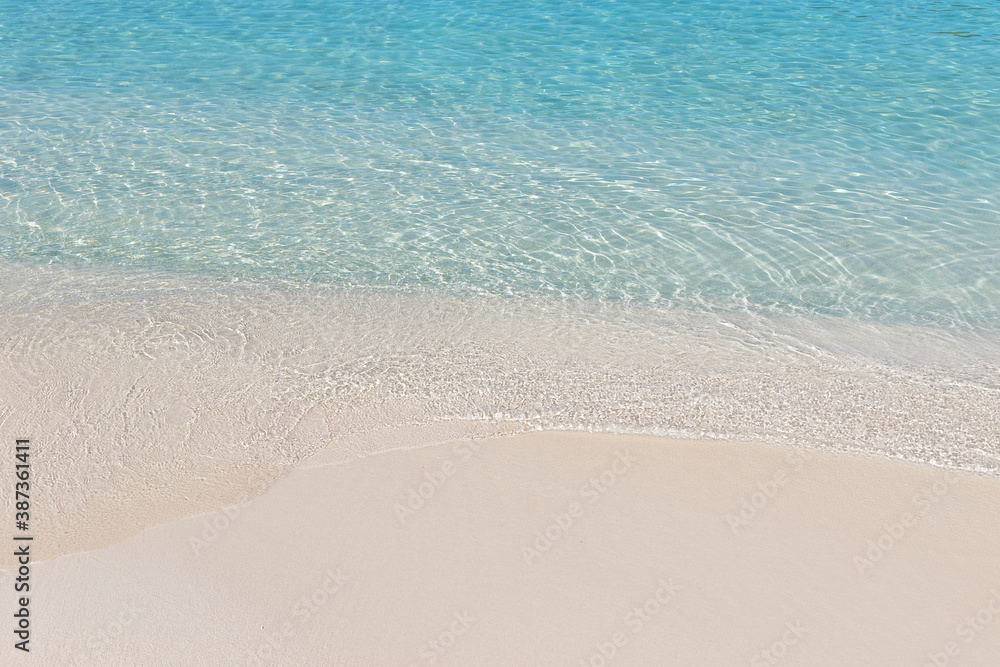Crystal clear water and sand on beach of Ksamil in Albania, border between the Adriatic and Ionian seas