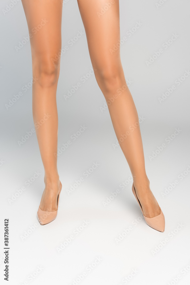 Cropped view of female legs in beige tights and shoes Cropped view of female legs in beige tights and shoes