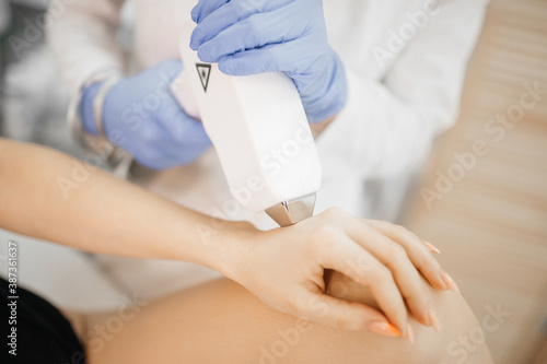 A girl does laser hair removal of her hand