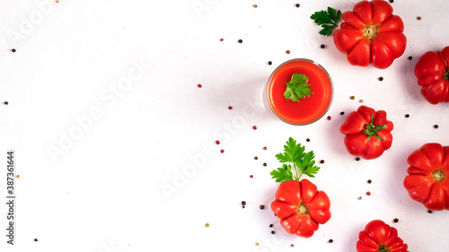 Fresh bright tomato juice with parsley leaves peppers and ripe tomatoes.