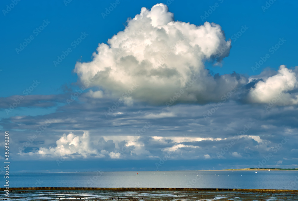 Wolken über dem Wattenmeer, Ostfriesland. Im Hintergrund Insel Langeoog.
