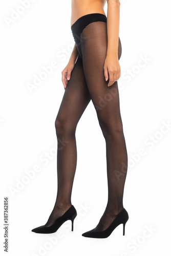 Cropped view of woman standing in black tights and shoes isolated on white
