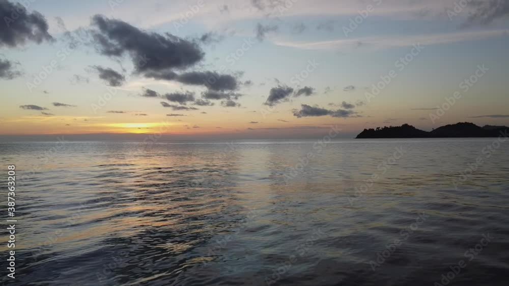 AERIAL: Drone is Traveling Super Low and than Gains the Altitude Above the Coastal Waves on the Sunset with Islands on the Background. Beautiful Koh Chang Island, Thailand, Asia. AERIAL: Drone is Traveling Super Low and than Gains the Altitude Above the Coastal Waves on the Sunset with Islands on the Background. Beautiful Koh Chang Island, Thailand, Asia.