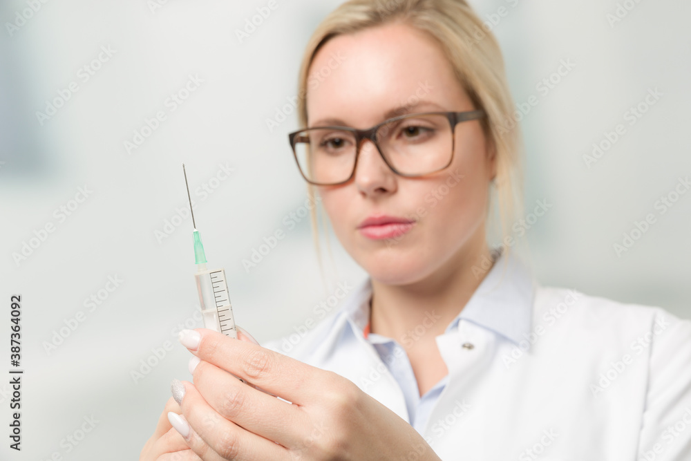 female doctor or nurse with syringe pulled up with a vaccination female doctor or nurse with syringe pulled up with a vaccination