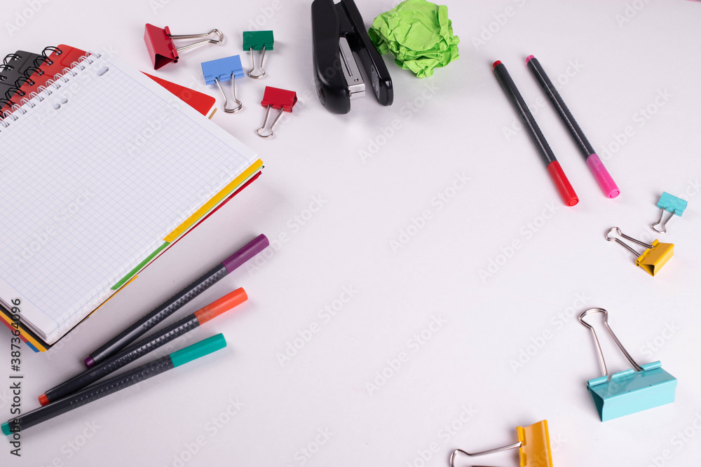 different stationary items of various colours on light surface. different stationary items of various colours on light surface.