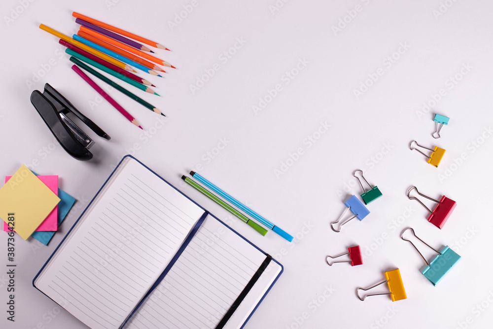 different stationary items of various colours on light surface. different stationary items of various colours on light surface.