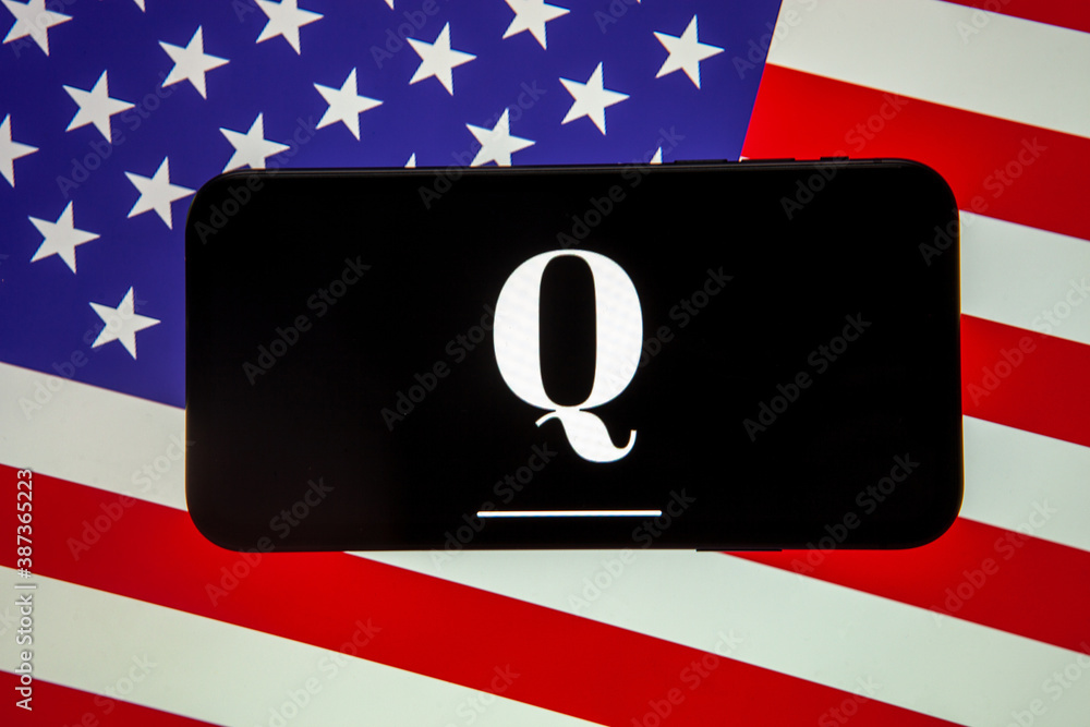 QAnon organisation logo seen on the smartphone which is placed on USA ...