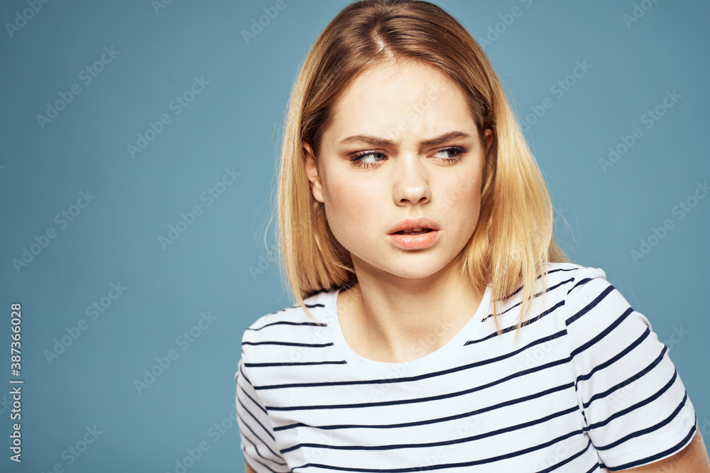 woman wearing striped t-shirt cropped view blue isolated background displeased facial expression woman wearing striped t-shirt cropped view blue isolated background displeased facial expression