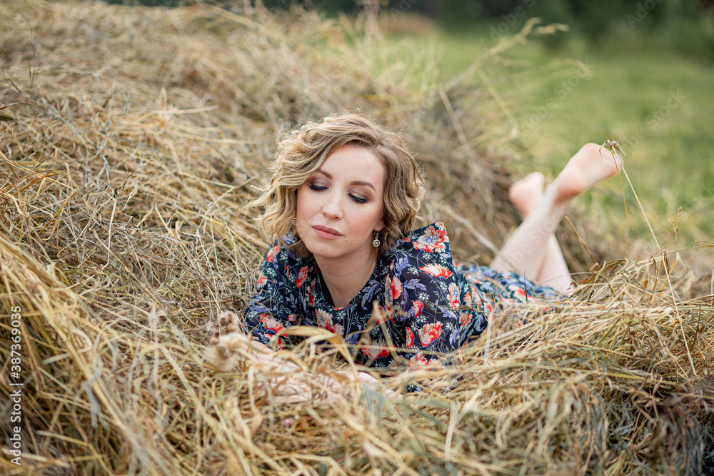 Portrait of a beautiful romantic young woman in the countryside at sunset. young attractive girl in a dress in a rustic style Portrait of a beautiful romantic young woman in the countryside at sunset. young attractive girl in a dress in a rustic style