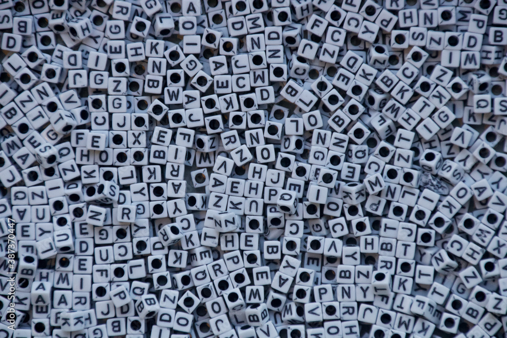 Cluster of white cube-shaped beads with black letters. Cluster of white cube-shaped beads with black letters.