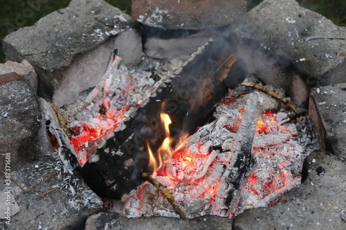 Self made campfire with embers  ashes  stones and coal as close up.