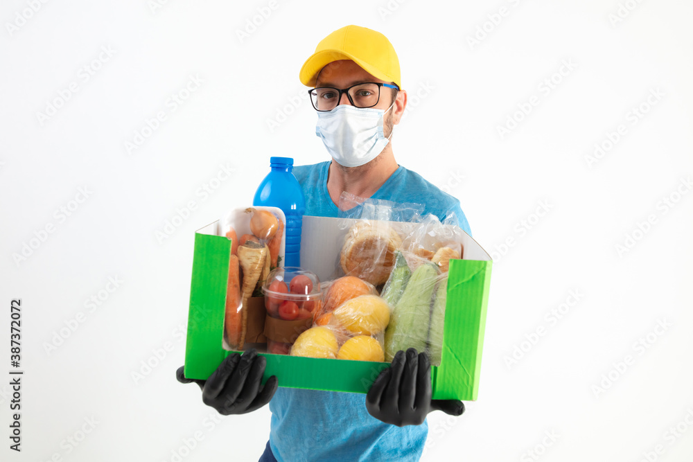 Delivery guy with protective mask holding box with groceries. Delivery guy with protective mask holding box with groceries.