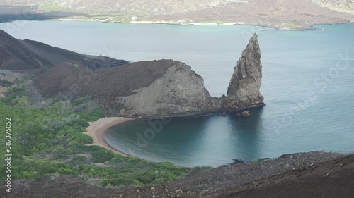 Pinnacle Rock Volcanic Formation with Green Forest and White Sandy Beach on Bartolome Island, Galapagos