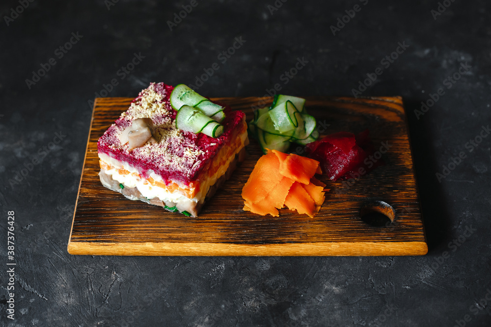 Dressed herring or herring under a fur coat. traditional Russian cuisine. Layered salad composed of diced pickled herring covered with layers of grated boiled vegetables and mayonnaise Dressed herring or herring under a fur coat. traditional Russian cuisine. Layered salad composed of diced pickled herring covered with layers of grated boiled vegetables and mayonnaise