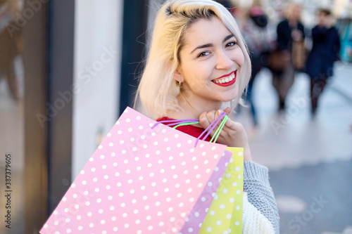 Portrait of young happy smiling woman with shopping bags