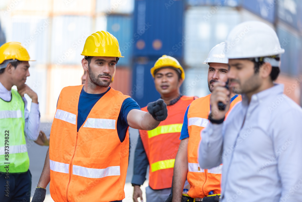 Strike of workers in container yard. Group of multiethnic engineer people during a protest in workplace Strike of workers in container yard. Group of multiethnic engineer people during a protest in workplace