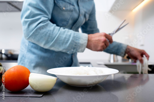 Cropped view of man cutting vegetables on chopping board at kitchen