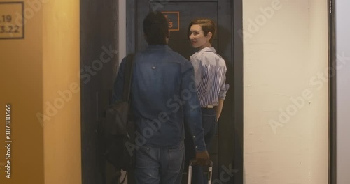 Wallpaper Mural Young interracial couple entering room in hostel or hotel and closing door. Charming Caucasian woman and handsome African American man with travel bag checking in. Tourists travelling together. Torontodigital.ca