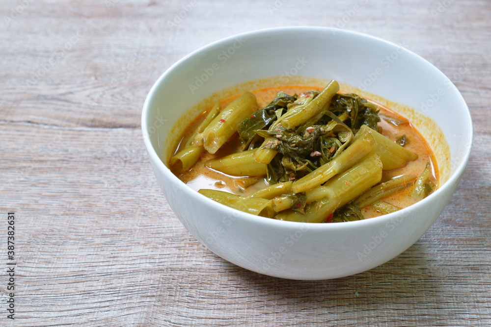 spicy boiled morning glory with fat pork in coconut milk curry or Kaeng The Po Thai food on bowl spicy boiled morning glory with fat pork in coconut milk curry or Kaeng The Po Thai food on bowl