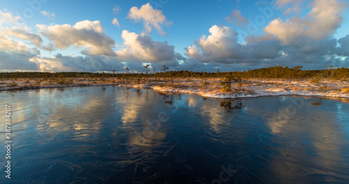 Swamp lake with islands in sunny winter day in sunrise © EriksZ
