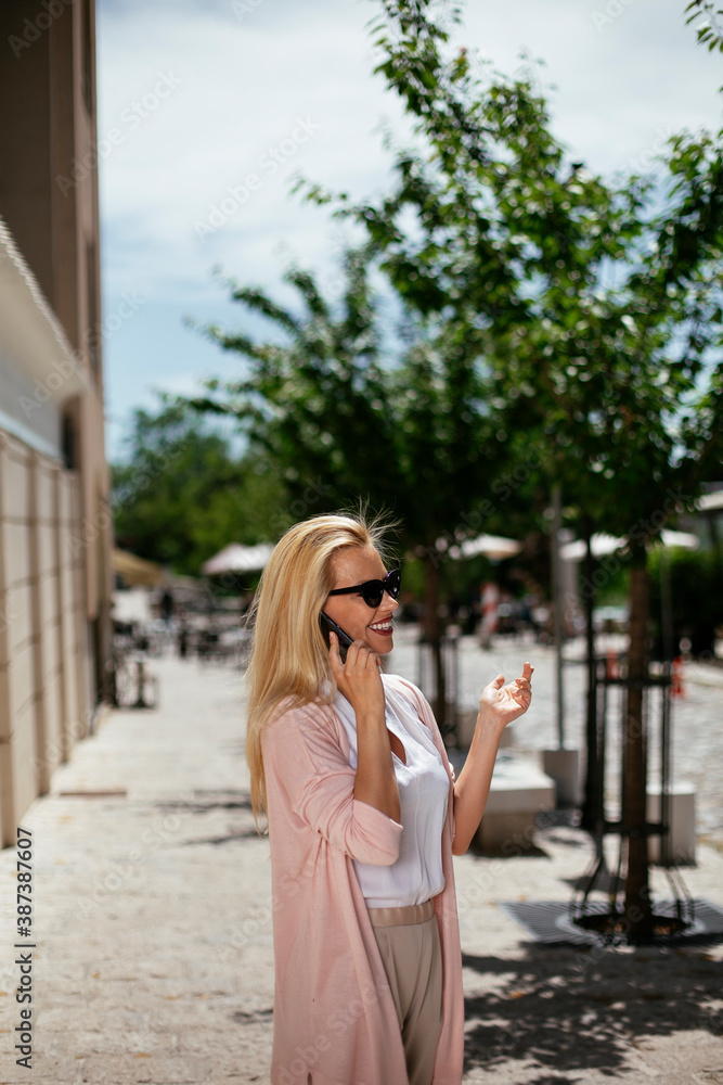 Beautiful businesswoman talking to the phone. Young woman outdoors..