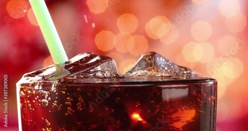 Cola and drink tube with Ice and bubbles in glass on a blurry light ,blurry background. photo