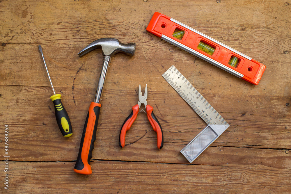 Orange tools on wooden surface Orange tools on wooden surface