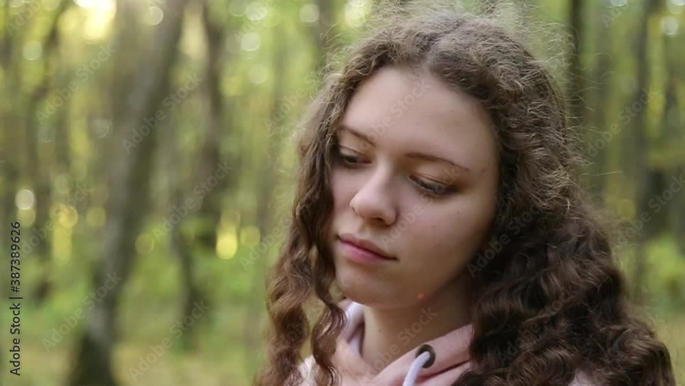 A teenage girl looks up thoughtfully, then looks up at the camera A teenage girl looks up thoughtfully, then looks up at the camera