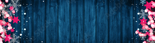 Christmas / Advent background banner Panorama, card template -Pink stars, bokeh lights, ice crystals and snowy snowflakes, isolated on dark blue wooden bards wall texture wood, with copy space