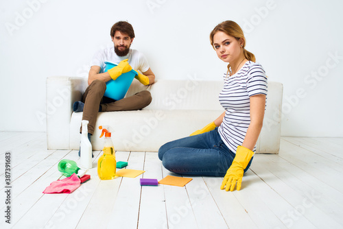 Woman washes the floors A man sits on the couch at home interior cleaning