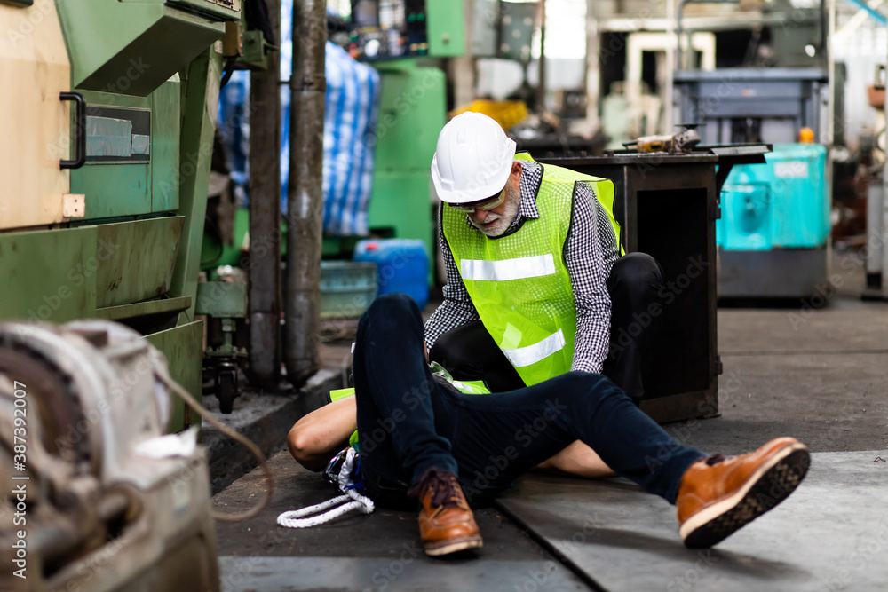 First Aid. Engineering supervisor talking on walkie talkie communication while his coworker lying unconscious at industrial factory. Professional engineering teamwork concept. First Aid. Engineering supervisor talking on walkie talkie communication while his coworker lying unconscious at industrial factory. Professional engineering teamwork concept.