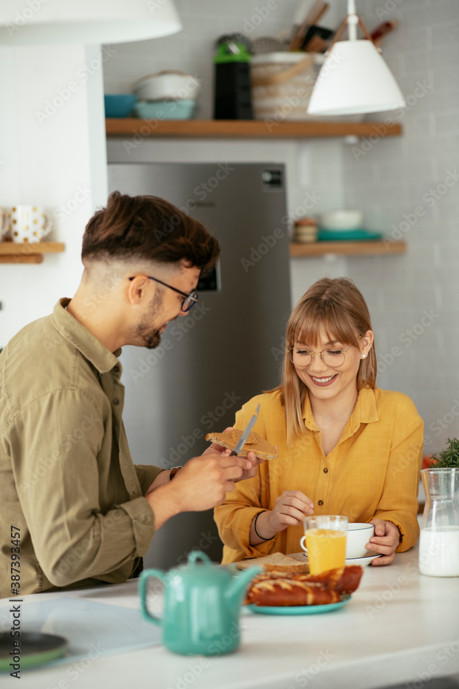 Young couple making sandwich at home. Loving couple enjoying in the kitchen.. Young couple making sandwich at home. Loving couple enjoying in the kitchen..