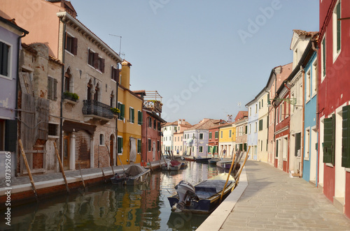 Burano is an island in the Venetian Lagoon  northern Italy  near Torcello at the northern end of the lagoon  known for its lace work and brightly coloured homes.