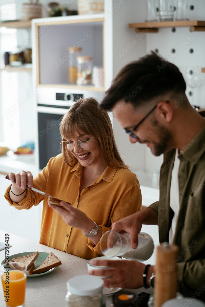 Young couple making sandwich at home. Loving couple enjoying in the kitchen.. Young couple making sandwich at home. Loving couple enjoying in the kitchen..