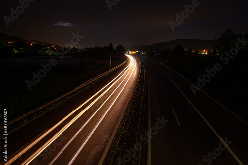 White car light trails on a motorway in night